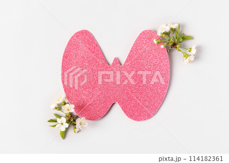 World Thyroid Day. Concept of thyroid disease and health. Pink Paper form of the thyroid gland on gray background with branches of cherry blossoms 114182361