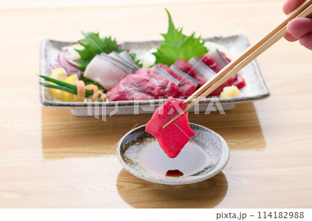 ミンク鯨の赤身と本皮のお刺身をお醤油につける 114182988