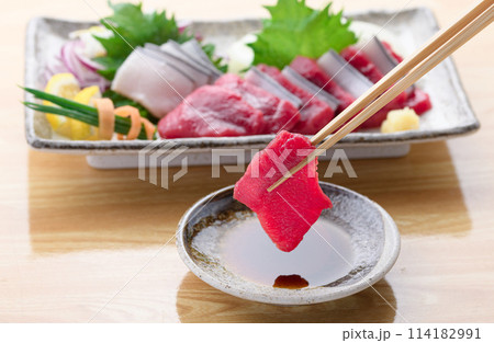 ミンク鯨の赤身と本皮のお刺身をお醤油につける ミンク鯨の赤身と本皮のお刺身をお醤油につける 114182991