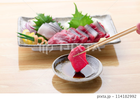 ミンク鯨の赤身と本皮のお刺身をお醤油につける 114182992