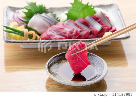 ミンク鯨の赤身と本皮のお刺身をお醤油につける 114182993