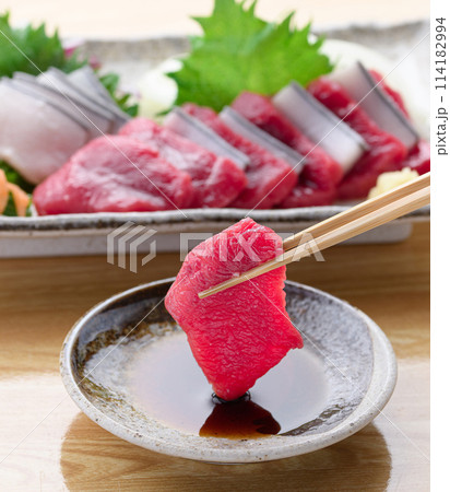 ミンク鯨の赤身と本皮のお刺身をお醤油につける 114182994