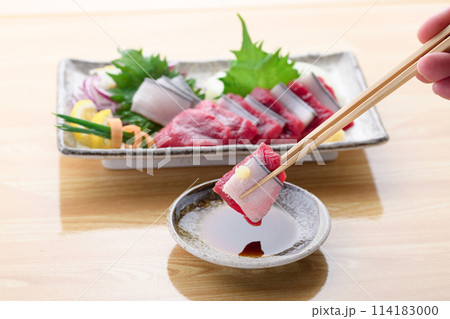 ミンク鯨の赤身と本皮のお刺身をお醤油につける ミンク鯨の赤身と本皮のお刺身をお醤油につける 114183000
