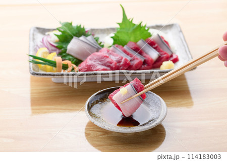 ミンク鯨の赤身と本皮のお刺身をお醤油につける 114183003