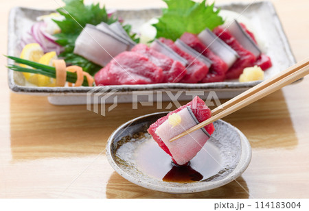 ミンク鯨の赤身と本皮のお刺身をお醤油につける ミンク鯨の赤身と本皮のお刺身をお醤油につける 114183004