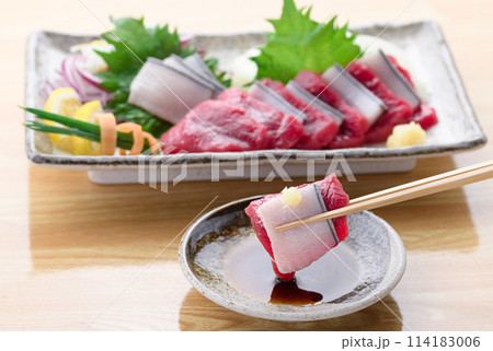 ミンク鯨の赤身と本皮のお刺身をお醤油につける 114183006