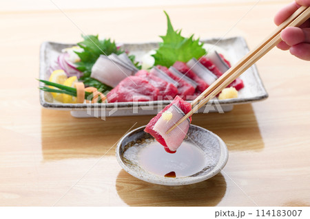 ミンク鯨の赤身と本皮のお刺身をお醤油につける 114183007