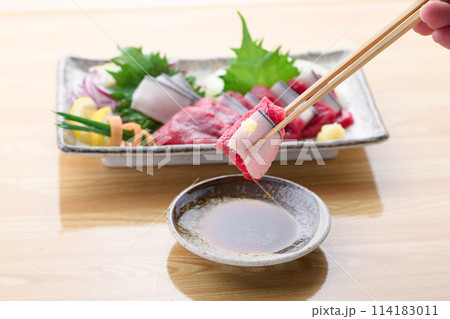 ミンク鯨の赤身と本皮のお刺身をお醤油につける ミンク鯨の赤身と本皮のお刺身をお醤油につける 114183011