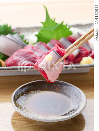 ミンク鯨の赤身と本皮のお刺身をお醤油につける 114183012