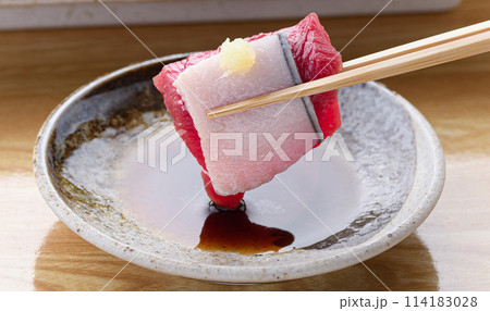 ミンク鯨の赤身と本皮のお刺身をお醤油につける 114183028
