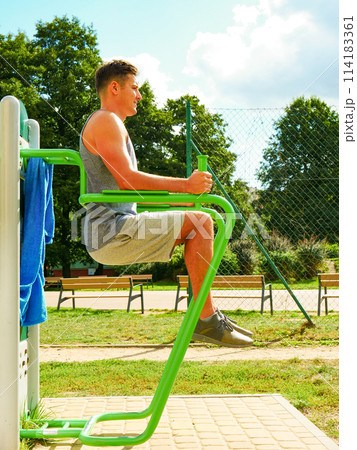 Man doing legs exercises in outdoor gym Man doing legs exercises in outdoor gym 114183361