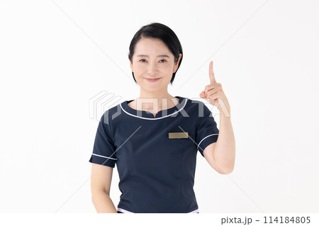 ミドル女性　エステティシャン　制服　指差し 114184805