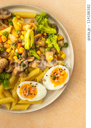 Pasta with fried mushrooms and broccoli, green peas and corn, fresh mix salad 114186382
