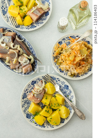 Boiled potatoes with pickled herring and sauerkraut 114186403