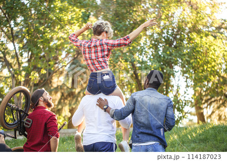 Young coupe in park. Boyfriend carrying his girlfriend on piggyback. 114187023