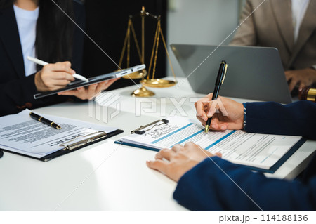 Business people and lawyers discussing contract papers sitting in the table at office in the morning. concepts of law, advice, legal services. Business people and lawyers discussing contract papers sitting in the table at office in the morning. concepts of law, advice, legal services. 114188136