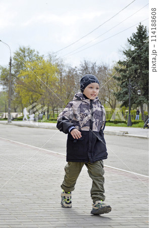 handsome boy runs along the sidewalk while walking handsome boy runs along the sidewalk while walking 114188608