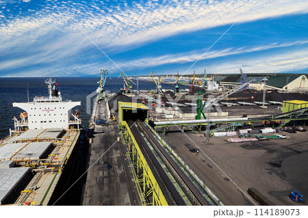 Coal Harbor and maritime bulk terminal with port cranes, coal embankments, bulk carriers at berth. Coal Harbor and maritime bulk terminal with port cranes, coal embankments, bulk carriers at berth. 114189073