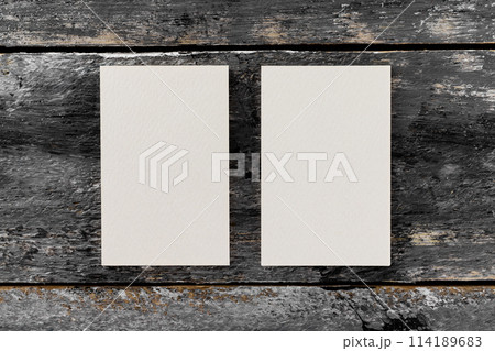 Mockup of two white vertical blank business cards at wooden vintage table background. 114189683