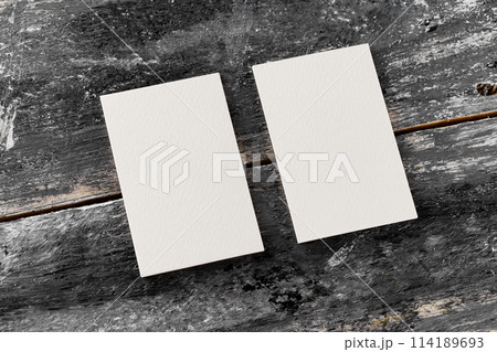 Mockup of two white vertical blank business cards at wooden vintage table background. 114189693