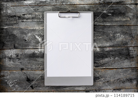 Top view mockup of clipboard and white blank letterhead at wooden vintage table background. 114189715