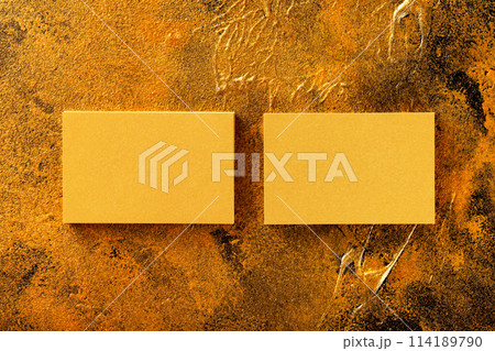 Flatlay mockup of two horizontal golden foil business cards at golden textured luxury background. 114189790