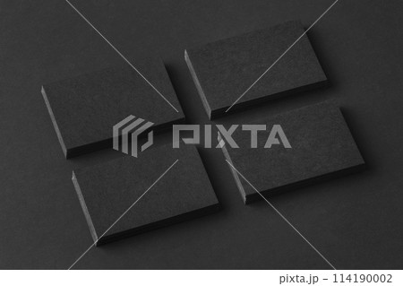 Mockup of four black business cards stacks arranged in rows at black paper background. 114190002