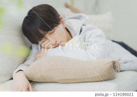 リビングでくつろぐ若い男性 114190021