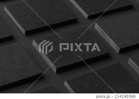 Mockup of horizontal business cards stacks arranged in rows at black textured paper background. 114190366