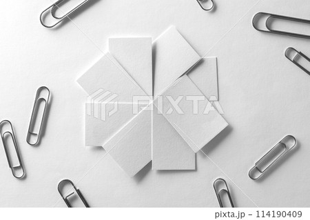 Blank business cards fan stack woth scattered clips at white textured paper background. 114190409