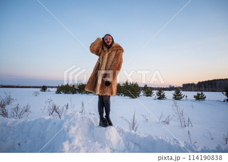 A beautiful girl in a fur coat walks and has fun in the winter forest A beautiful girl in a fur coat walks and has fun in the winter forest 114190838