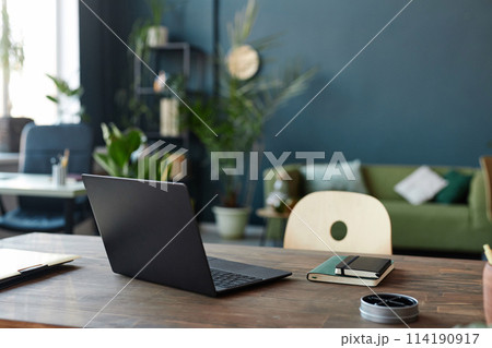 Background image of open laptop at workplace table in office with blue wall copy space Background image of open laptop at workplace table in office with blue wall copy space 114190917