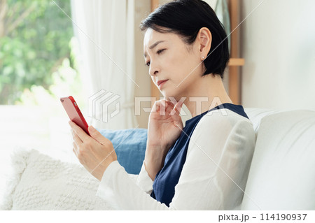 リビングでスマホを使う女性 リビングでスマホを使う女性 114190937
