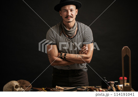 Craftsman posing on his working place with crafting tools 114191041