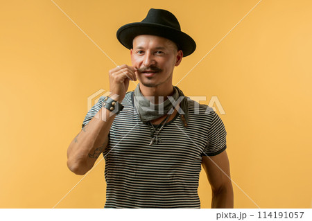 Happy man with moustache wearing hat isolated over yellow background. Happy man with moustache wearing hat isolated over yellow background. 114191057