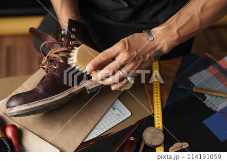 Cleaning shoes on wooden background. black shoe with a brush 114191059