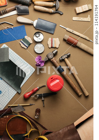 Set of leather craft tools on paper background. Workplace for shoemaker. 114191764