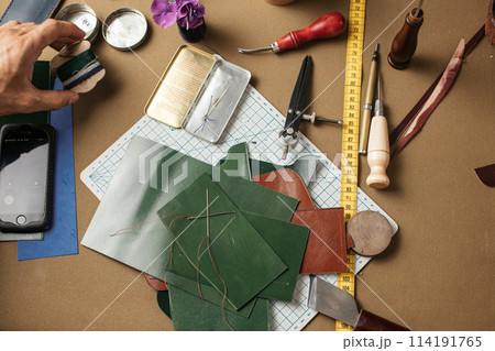 Set of leather craft tools on paper background. Workplace for shoemaker. 114191765