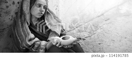 Girl with an empty lamp sits on the ground Girl with an empty lamp sits on the ground 114191785
