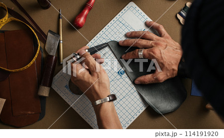 Working process of producing hand made leather wallet in the leather workshop. Working process of producing hand made leather wallet in the leather workshop. 114191920