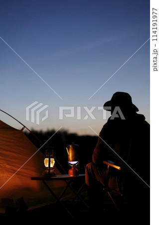 夕暮れのキャンプを楽しむ男性 114191977