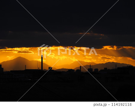 雲の隙間から顔を出すオレンジ色の夕焼け 雲の隙間から顔を出すオレンジ色の夕焼け 114192118
