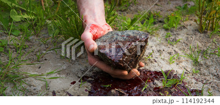Bloodied hand with big stone Bloodied hand with big stone 114192344