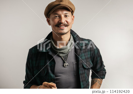 Cheerful craftsman selling online self made leather goods via smartphone. 114192420