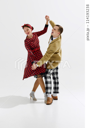 Elegant, charming young couple, man and woman in retro style clothes dancing isolated over white studio background 114193238