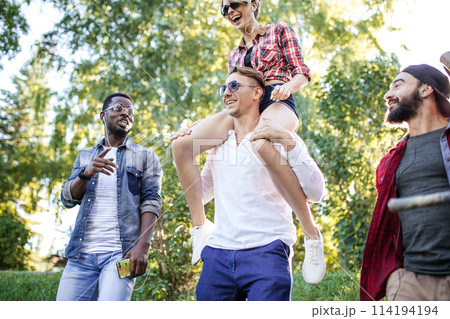 Multicultural group of friends walking together and having fun day outdoors. Multicultural group of friends walking together and having fun day outdoors. 114194194