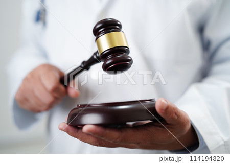 Asian doctor holding court hammer for and crime law justice, forensic medicine. Asian doctor holding court hammer for and crime law justice, forensic medicine. 114194820