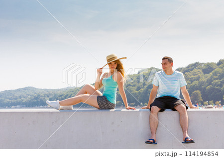 Man and woman sitting together outside Man and woman sitting together outside 114194854