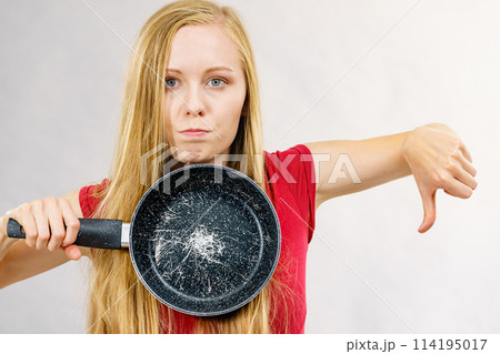 Girl holding scratched frying pan 114195017
