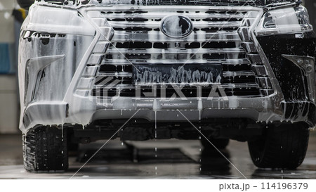 Foam drips from the bumper of a black car. Car wash. Foam drips from the bumper of a black car. Car wash. 114196379